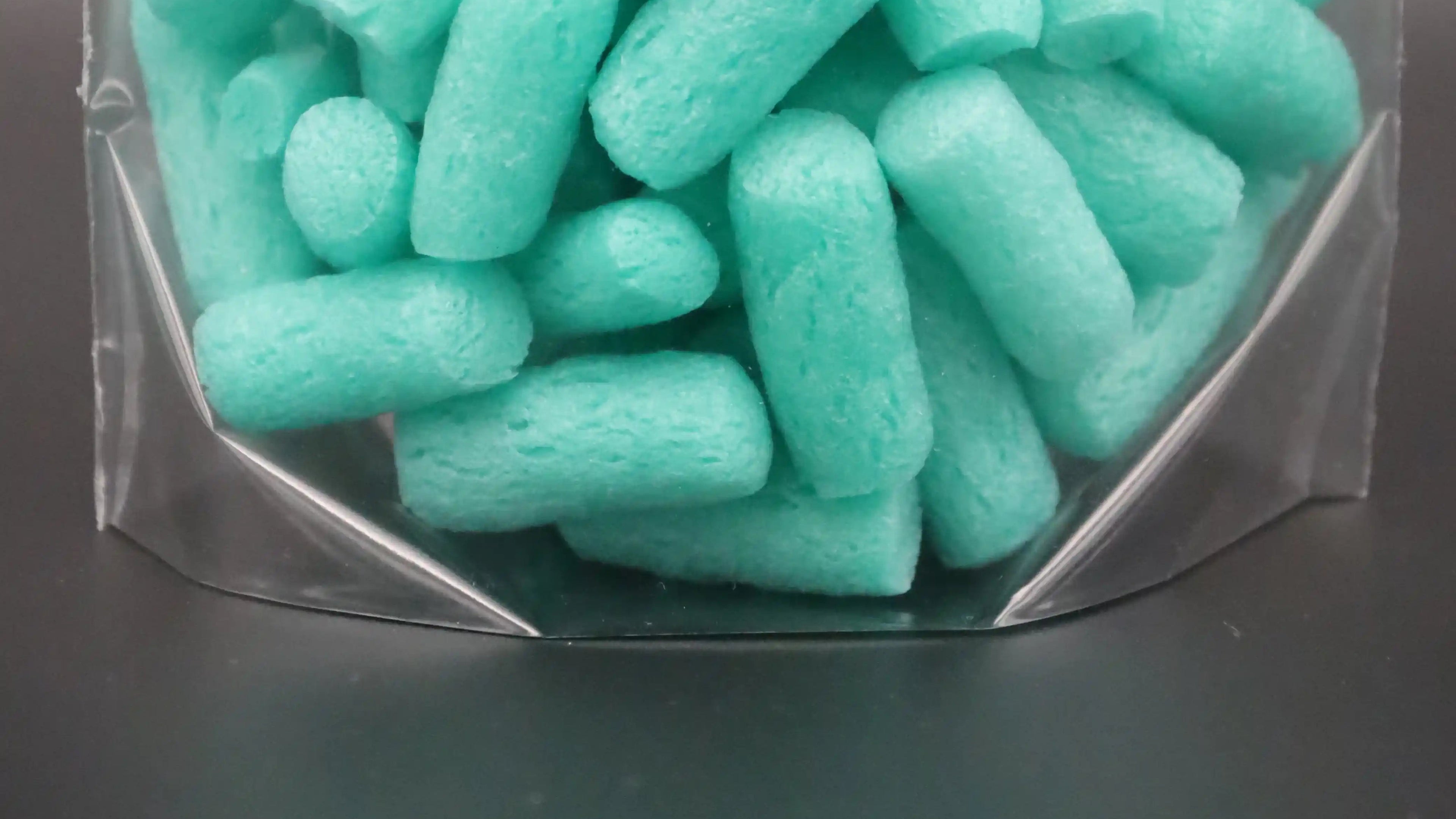 Detailaufnahme eines transparenten Bodenfaltenbeutels mit türkisfarbenem Verpackungsmaterial – ideale Verpackungslösung für voluminöse Produkte