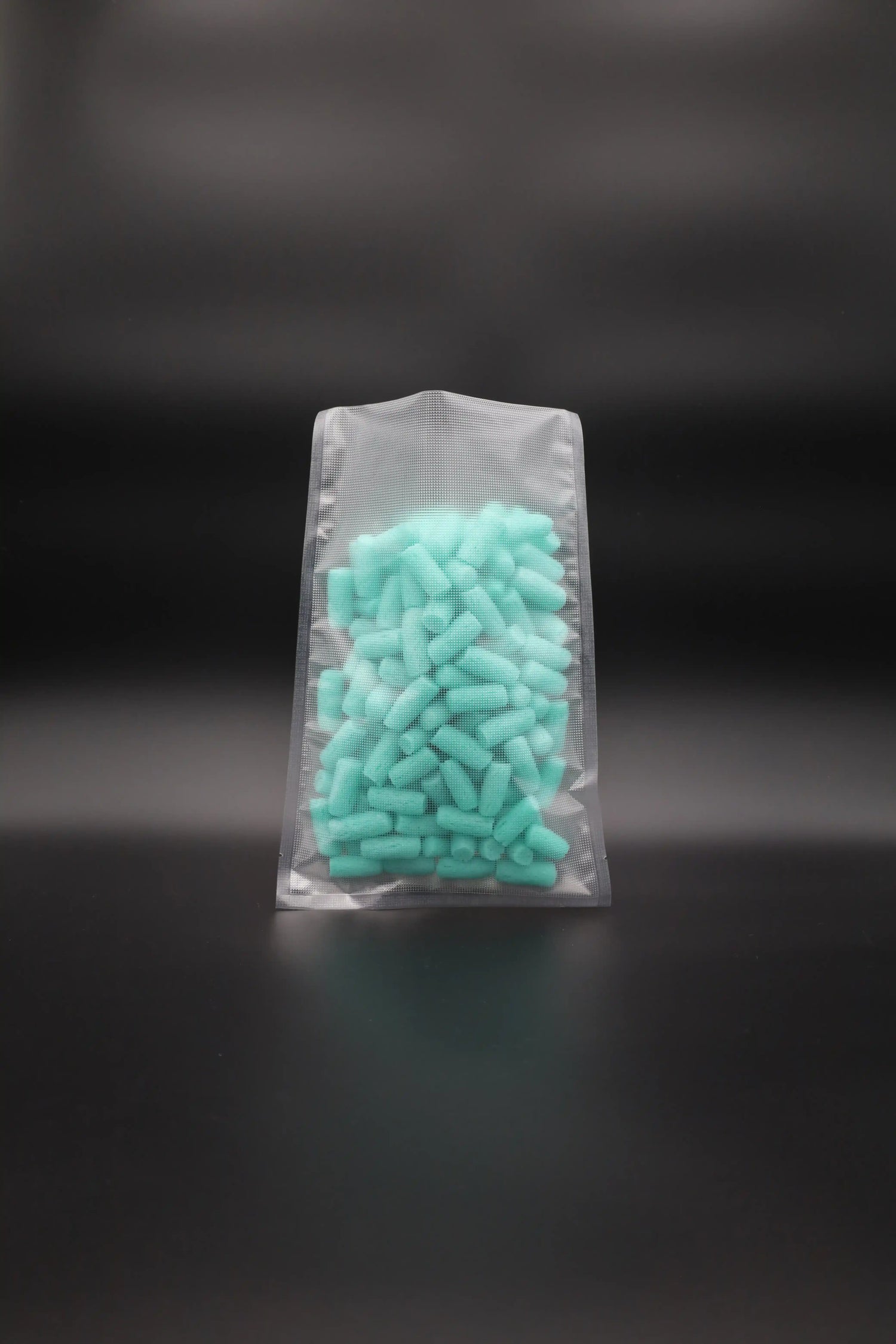 Strukturierter Vakuumbeutel mit türkisfarbenem Füllmaterial – ideal zur luftdichten Verpackung von Lebensmitteln, Technik- oder Hygieneprodukten