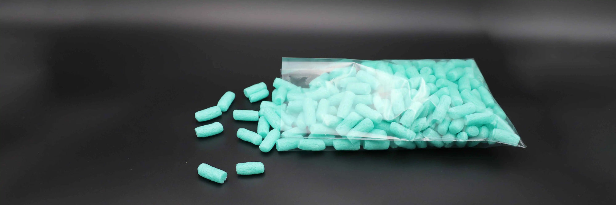 Transparenter Flachbeutel mit türkisfarbenem Füllmaterial, teilweise geöffnet – flexible Verpackungslösung für leichte Schüttgüter oder Versandmaterialien, ideal für Lagerung und Transport.