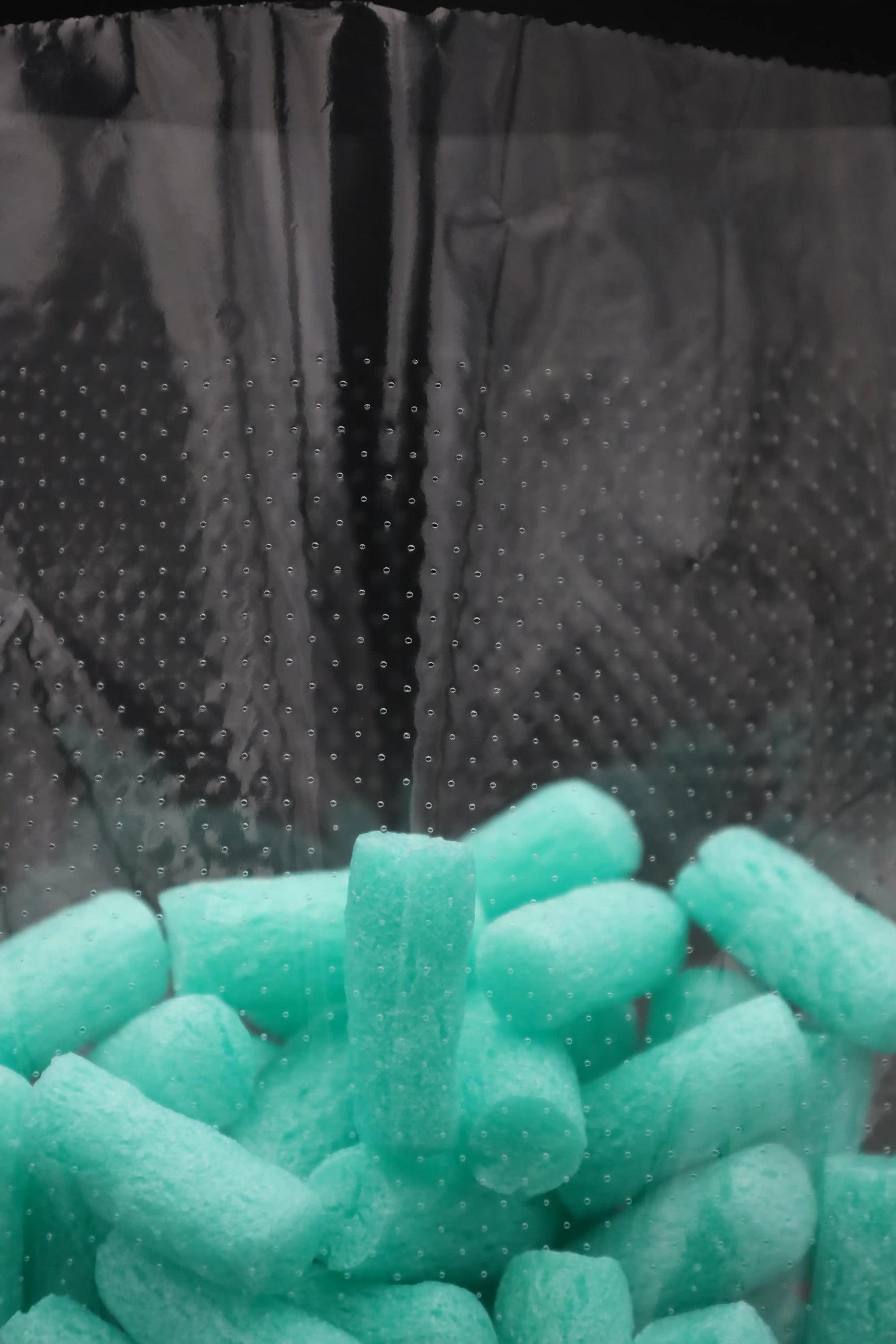 Detailansicht eines mikroperforierten Kunststoffbeutels mit türkisfarbenem Füllmaterial – luftdurchlässige Verpackungslösung für frischeempfindliche Produkte.